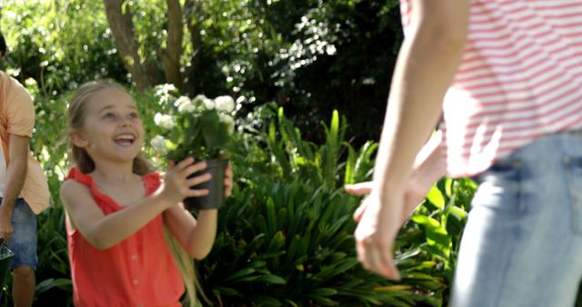 Happy Girl Presenting Plant to Parent in Garden - Download Free Stock Images Pikwizard.com