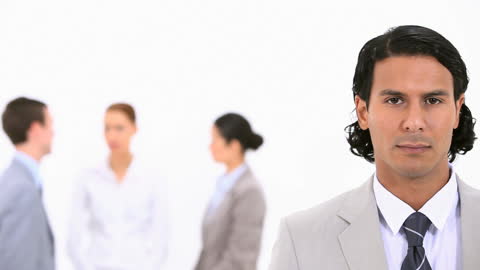 Confident Businessman in Office Environment with Colleagues