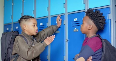 Two schoolboys engaging in conversation by the lockers