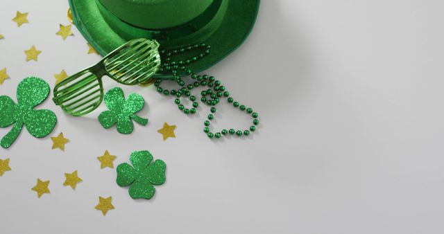 Shamrocks and stars with green hat and glasses with copy space on white background. Irish tradition and st patrick's day celebration concept digitally generated image.