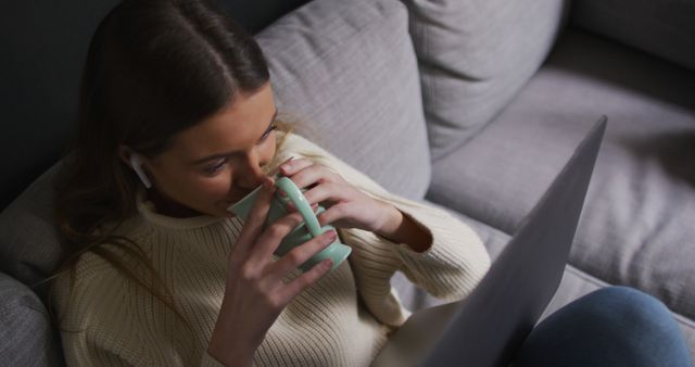 Young Woman Drinking Coffee while Working at Home on Laptop - Download Free Stock Images Pikwizard.com