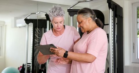 Senior couple enjoying tablet discussion in home gym