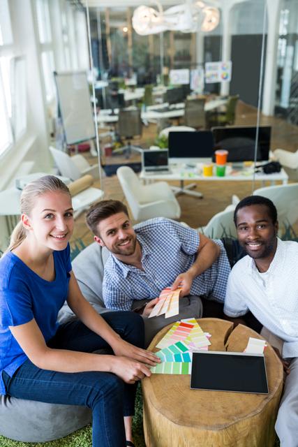 Group of graphic designers smiling and sitting together in office