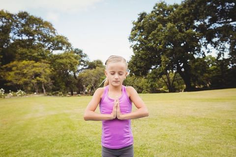 Child Meditating Outdoors in Serene Park Setting
