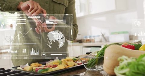 Seasoning vegetables with smart kitchen hud, woman grinding pepper over tray