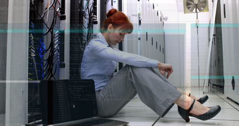 Exhausted it engineer sitting in server room counteracting digital vortex