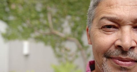 Serene mature man partially face view in lush courtyard