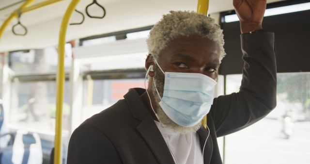 African american senior man wearing face mask travelling in the bus. hygiene and social distancing during coronavirus covid-19 pandemic.