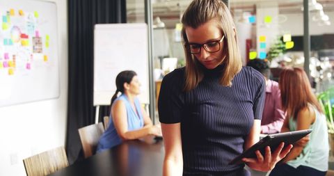 Young Businesswoman Multitasking with Tablet and Phone in Modern Office - Download Free Stock Images Pikwizard.com