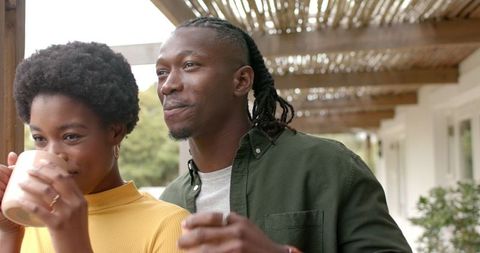 Couple Enjoying Warm Beverages on Rustic Wooden Porch