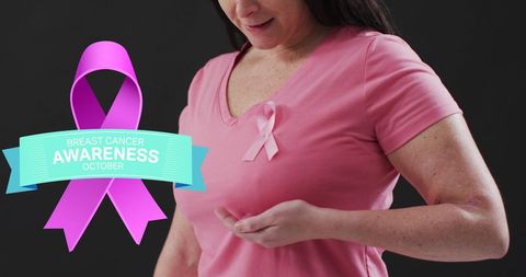 Middle-aged woman wearing pink ribbon for breast cancer awareness