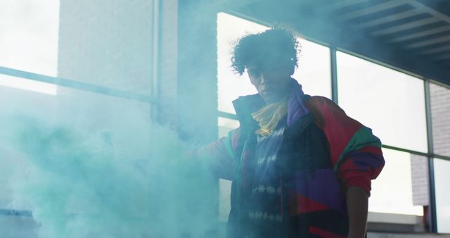 Stylish Young Man with Curly Hair Standing in Blue Smoke - Download Free Stock Images Pikwizard.com