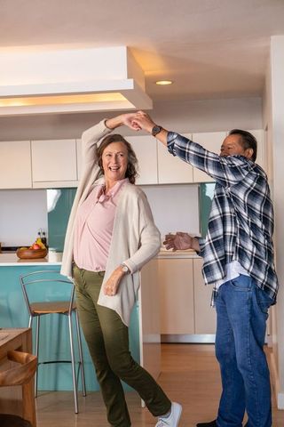 Diverse Couples Friendship Enjoying Dance in Bright Home Kitchen