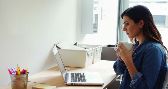 Young Woman Working on Laptop While Drinking Coffee at Home Office - Download Free Stock Images Pikwizard.com