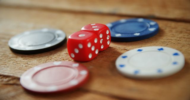 Close-up of casino chips and dice on wooden table in casino