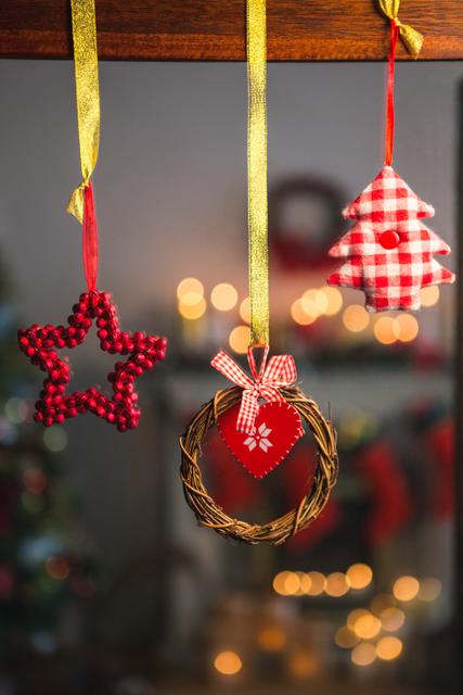 Close-up of Christmas ornaments including a grapevine wreath, a star, and a tree hanging on ribbons. Perfect for holiday-themed projects, festive greeting cards, seasonal advertisements, and home decor inspiration.