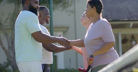 Diverse Group Greeting Each Other with Handshakes Outdoors