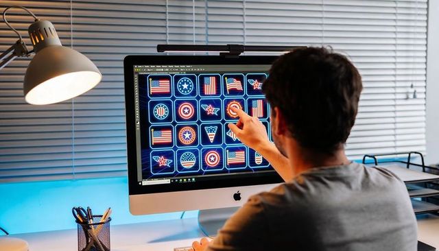 Designer selecting neon american badge icons on desktop imac in modern home office ui grid