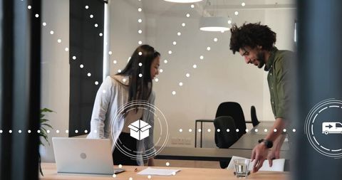 Young professionals collaborating at meeting table in modern minimalist office with laptop