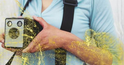 Woman holding vintage box camera with artistic yellow effect