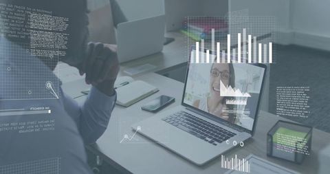 Mature businessman leaning at desk viewing laptop for remote meeting with analytics HUD