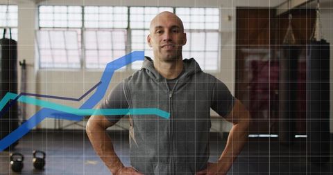 Confident fitness coach standing in gym with performance data overlays and kettlebells