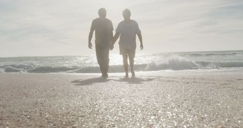 Senior Couple Walking Hand in Hand on Scenic Beachfront