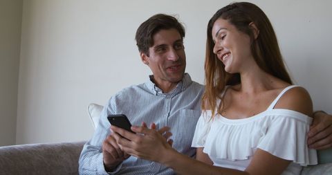 Couple Smiling Together Using Smartphone on Couch - Download Free Stock Images Pikwizard.com