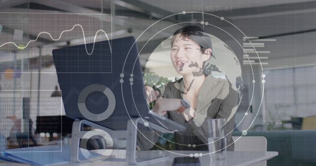 Image of data processing and globe over happy asian businesswoman using laptop. Global business and digital interface concept, digitally generated image.