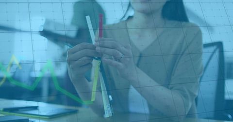 Businesswoman analyzing data overlaid with financial statistics