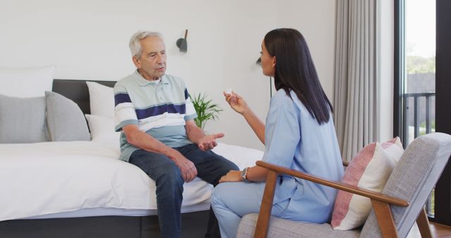 Image of biracial female doctor giving pills to caucasian senior man. seniors health and nursing home lifestyle concept digitally generated image.