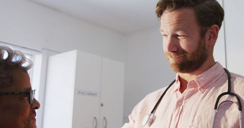 Friendly Doctor Consulting Elderly Patient in Healthcare Setting