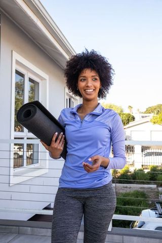 Afro-American Woman Enjoying Outdoor Yoga Preparedness on Balcony