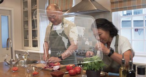 Senior couple chopping vegetables and cooking at kitchen island with hud map overlay