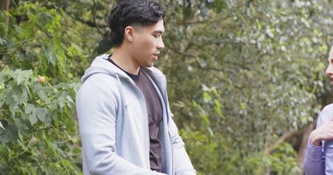 Young friends having casual conversation during wooded park walk outdoor relaxation day