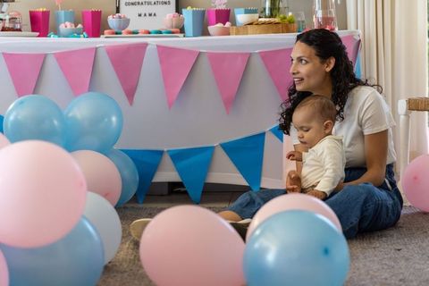 Mother celebrating special occasion with baby among pastel decorations