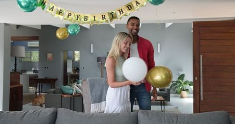 Couple Adding Birthday Balloons for Indoor Celebration
