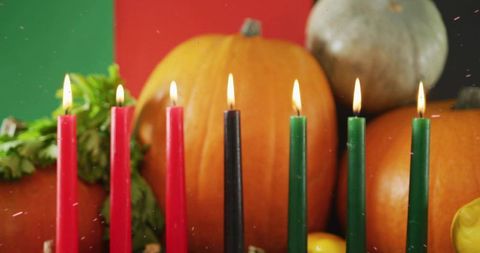 Kwanzaa kinara burning among pumpkins and gourds fall harvest centerpiece celebration