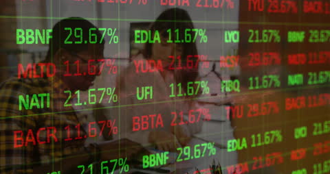 Graphic Designers Collaborating with Stock Market Data Overlay