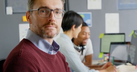 Confident male executive with diverse team working in modern office