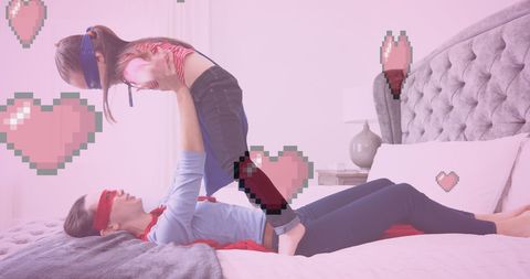 Joyful Mother and Daughter Playing Superheroes at Home