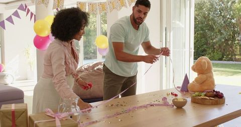 Diverse Couple Decorating for Birthday Celebration at Home