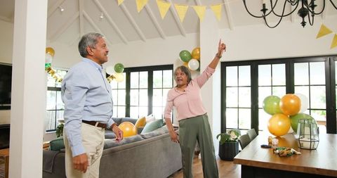 Seniors Joyfully Decorating Living Room for Festive Birthday Celebration