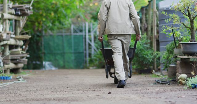 Gardener Working in Peaceful Garden Walking Away with Wheelbarrow - Download Free Stock Images Pikwizard.com