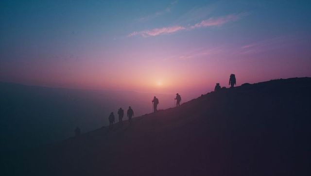 Hikers Climbing Ridge During Majestic Dawn Adventure