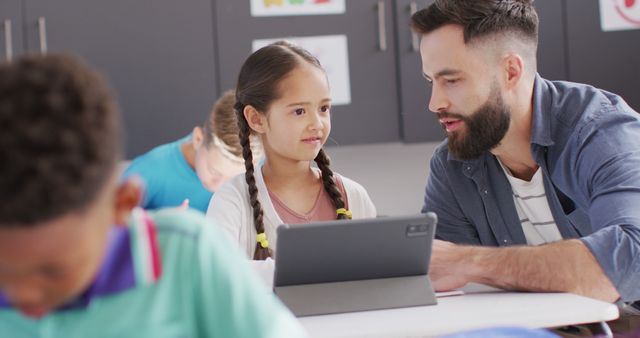 Teacher Using Tablet to Teach Young Student in Classroom - Download Free Stock Images Pikwizard.com