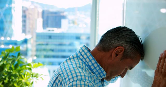 Stressed Businessman Leaning on Window with City View - Download Free Stock Images Pikwizard.com