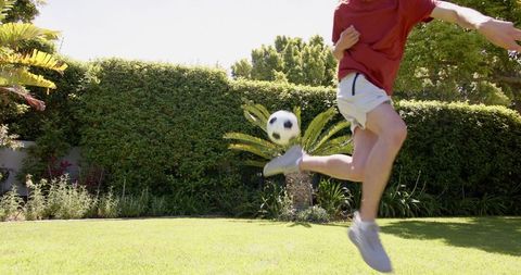 Youth Practicing Soccer Juggling Skills in Home Garden