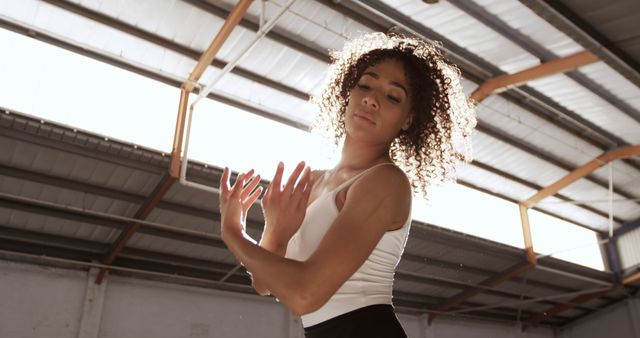 Expressive Young Woman Dancing with Sunlight in Industrial Space - Download Free Stock Images Pikwizard.com