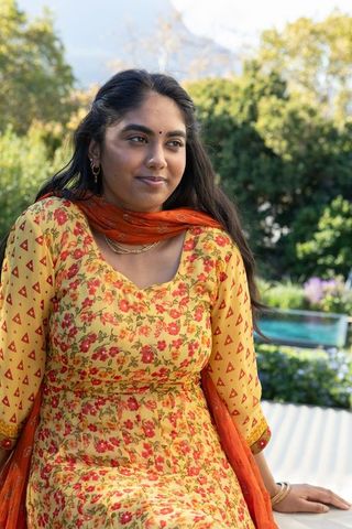 Outdoor Serenity: Woman in Elegant Traditional Indian Attire Relaxing by Garden Pool